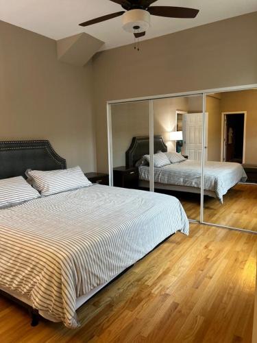 a bedroom with two beds and a large mirror at Gorgeous North Kenwood Hyde Park Unit in Chicago