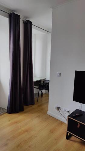 a living room with a curtain and a table at Casa ao centro - Apartamento Angrego in Angra do Heroísmo