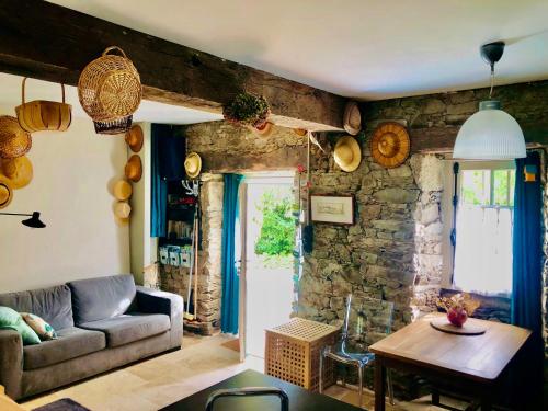 un salon avec un canapé et une table dans l'établissement Gîte le Saint Couette 4 étoiles, charme & confort chic, à Saint-Colombin