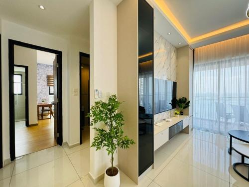 a living room with a potted plant in the middle at JB Country Garden Danga Bay by J Agape Homestay in Johor Bahru