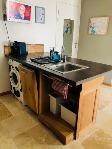 - un comptoir de cuisine avec évier et lave-linge dans l'établissement Gîte le Saint Couette 4 étoiles, charme & confort chic, à Saint-Colombin