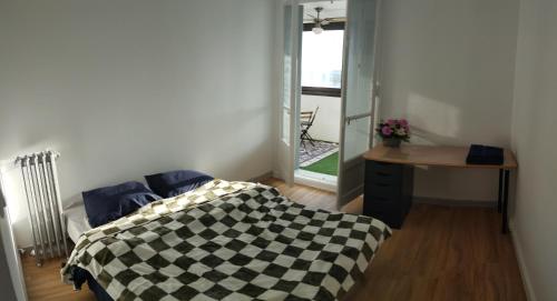 une chambre avec un lit, une table et une fenêtre dans l'établissement Vue imprenable, à Toulouse