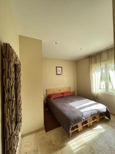 a bedroom with a bed in a room with a window at Maison de campagne profitez vue exceptionnelle in Bessins