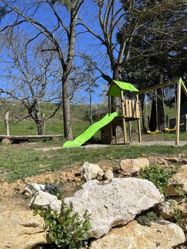 a playground with a green slide in a park at Maison de campagne profitez vue exceptionnelle in Bessins