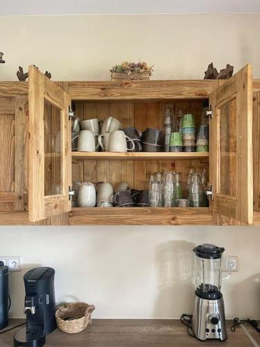a kitchen cabinet with cups and a blender in it at Maison de campagne profitez vue exceptionnelle in Bessins