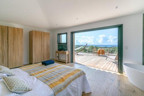 une chambre avec un grand lit et un balcon dans l'établissement Les chambres Marcelle, à Pianottoli-Caldarello