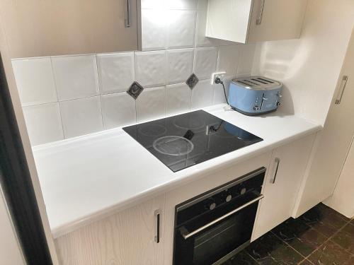 a kitchen with a stove and a counter top at Entire Family Home with private pool in Townsville