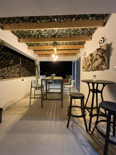 a room with tables and chairs and a wall with paintings at Le Voyageur By the Sea - Furnished Rooms in Larnaka