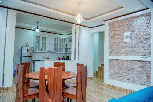 Una cocina y un comedor con mesa y sillas de madera. en Prime Luxury Apartments, en Kigali
