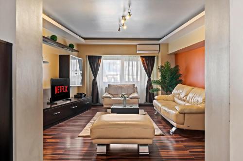 Una sala de estar con un sofá y un televisor. en 4 Rooms Unirii 47, en Bucarest