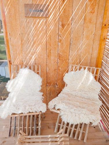 two white chairs sitting next to a wall at Garden12 Outdoor & More in Douz