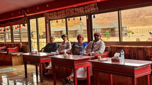 a group of people sitting at tables in a restaurant at Dream Bedouin Life Camp Wadi Rum in Disah
