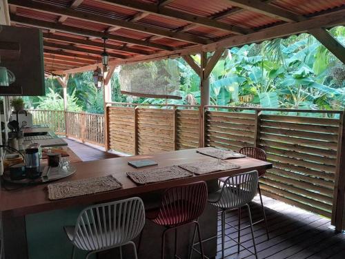 an outdoor kitchen with a table and chairs on a deck at Habitation Madame Rosalie in Vieux-Habitants