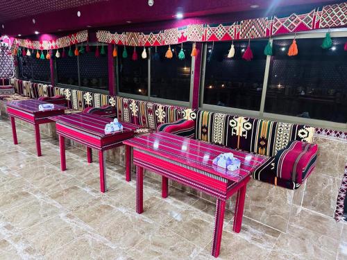 a row of red benches sitting in a room at Dream Bedouin Life Camp Wadi Rum in Disah