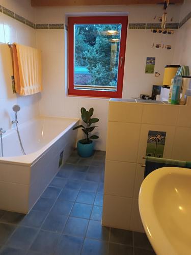 a bathroom with a tub and a sink and a window at FEWO Villa Farbenfroh Monteurzimmer Garten Wlan 3SZ 120qm in Wathlingen
