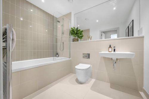a bathroom with a toilet and a sink and a tub at Apartment by the beach in Rest Bay, Porthcawl in Porthcawl