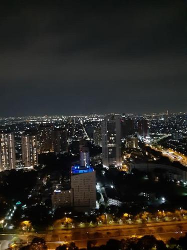 a view of a city at night with lights at Menara Jakarta Condo JI Expo PRJ by Blezz in Jakarta