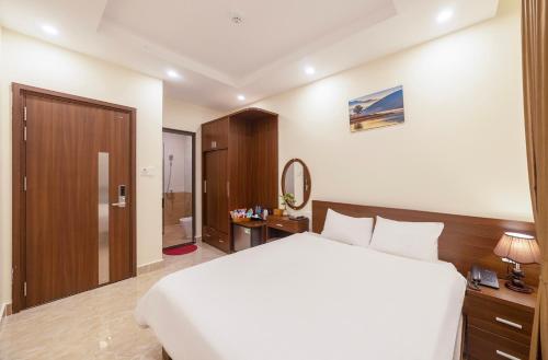 a hotel room with a bed and a bathroom at Huyền 179 in Da Lat