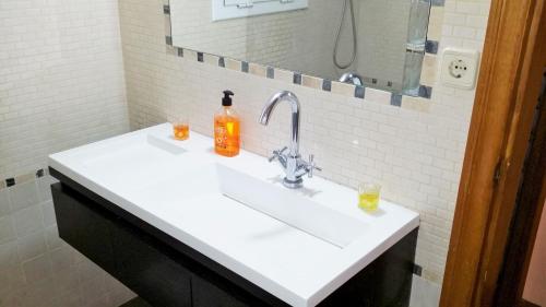 a bathroom sink with a bottle of soap on it at Carmen Seaview & Beach - Apartment in Montgat