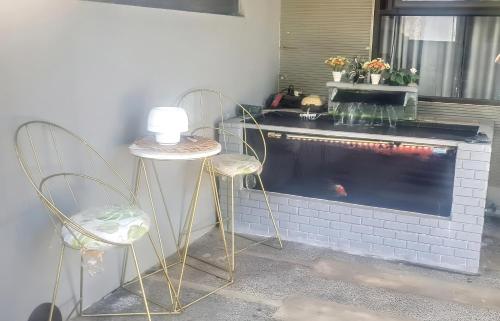 two chairs and a table in front of a fireplace at Nita's Sweet Home Tidar Malang Close to Soehat in Kasri