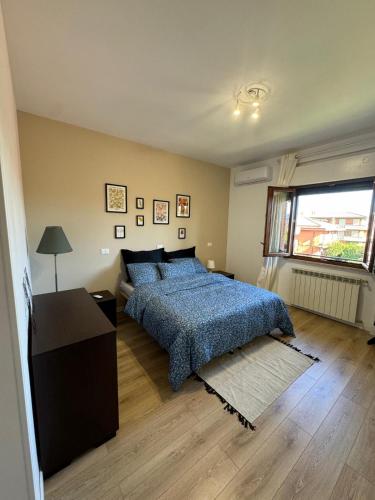 a bedroom with a blue bed and a window at La Casa di Enea in Rome