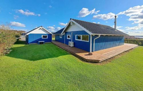 a blue house with a wooden deck in a yard at Holiday Home Lerskrænten Vinderup I in Vinderup