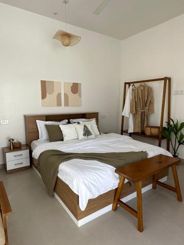 a bedroom with a large bed and a table at Wadi Bani Khalid - Al Joud Green Hostel 2 in Dawwah