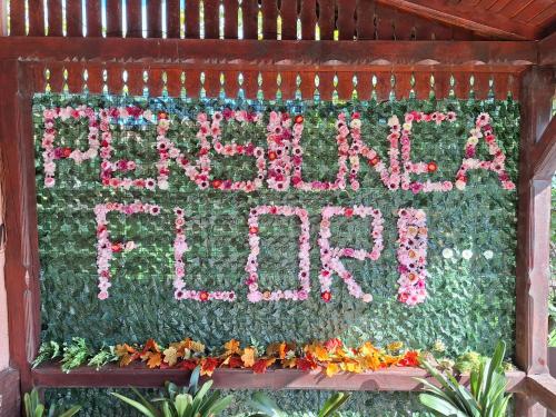 a sign that says happy new year with flowers at Pensiunea Flori in Vaţa de Jos
