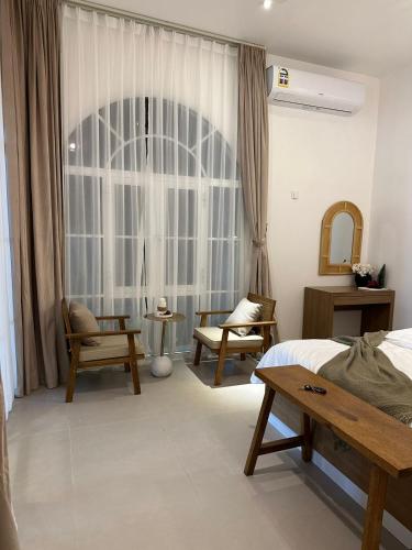 a bedroom with a bed and a large window at Wadi Bani Khalid - Al Joud Green Hostel 2 in Dawwah