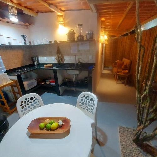 a kitchen with a table with a bowl of fruit on it at Residência Thomas in Itacaré