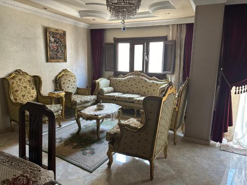 Una sala de estar con un sofá y sillas y una mesa. en Appartement, en El Mansurá