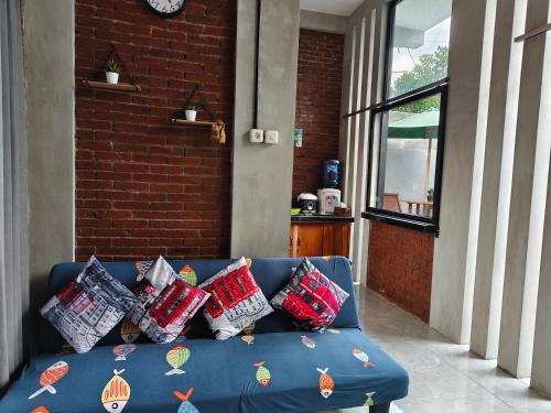 a blue couch with pillows on top of it at Villa Pondok Kelapa Batu in Batu