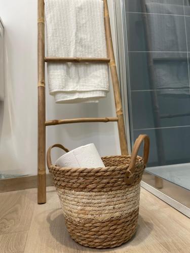 a basket sitting on the floor next to a towel rack at Le Cocon à Muret in Muret