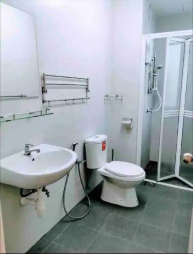 a bathroom with a toilet and a sink and a shower at daisy apartment homestay taiping in Taiping