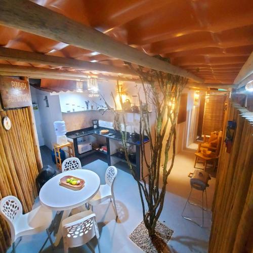 a room with a table and chairs and a kitchen at Residência Thomas in Itacaré