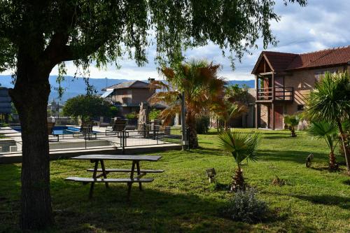 een picknicktafel onder een boom in een park bij Altos de Brochero Cabañas & Padel in Villa Cura Brochero