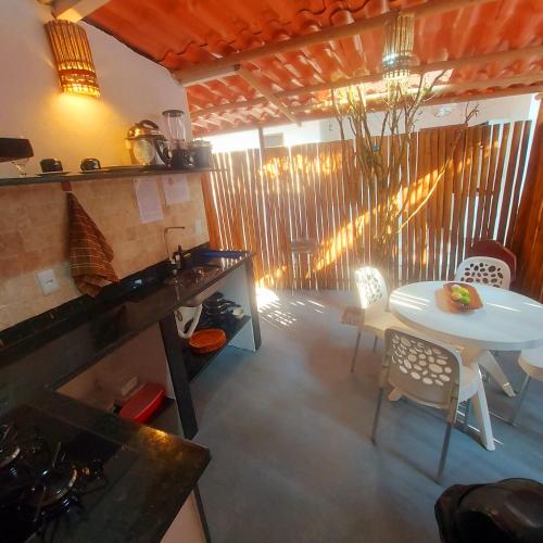 a kitchen with a table and a white table and chairs at Residência Thomas in Itacaré