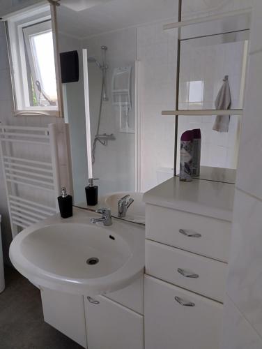 a white bathroom with a sink and a window at Vakantie chalet Utrechtse Heuvelrug in Overberg