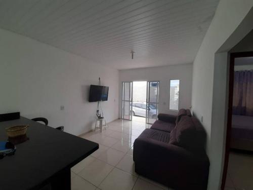 a living room with a couch and a table at Linda casa na Gamboa Garopaba in Paulo Lopes