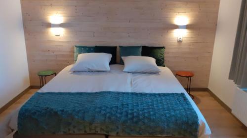 a bedroom with a large bed with two stools at Huyze Vinck in Veurne