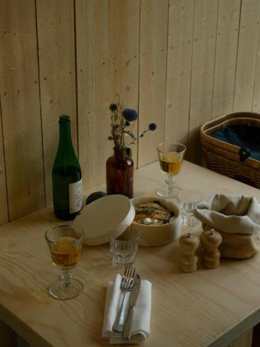 a table with a bottle of wine and wine glasses at Youza ecolodge in La Couture-Boussey