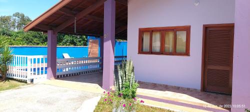 a house with a porch and a swimming pool at Temporada Belas Casas in São Pedro