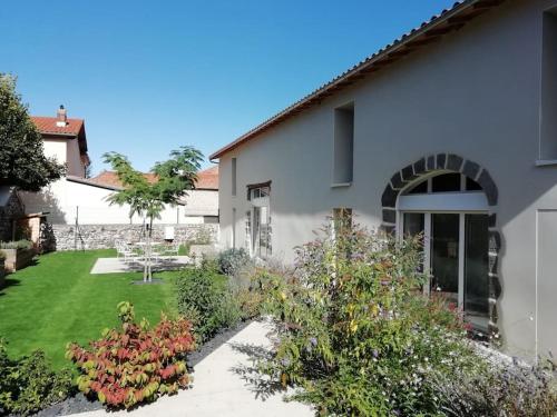 un jardin en face d'une maison blanche dans l'établissement Résidence familiale au calme adaptée PMR, à Meilhaud