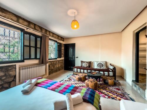 a bedroom with two beds and a couch at Tonaroz House in Imlil