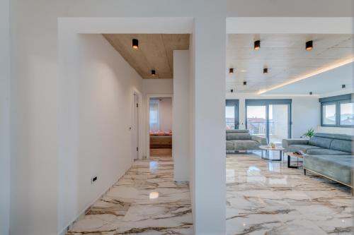 ein Wohnzimmer mit weißen Wänden und Steinboden in der Unterkunft Luxury Villa Providenza in Kaštela