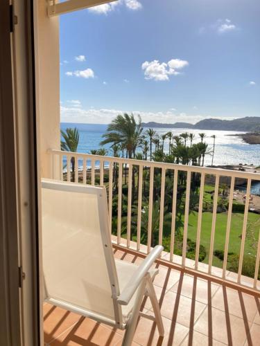 a white chair sitting on a balcony overlooking the ocean at Parador de Jávea in Jávea