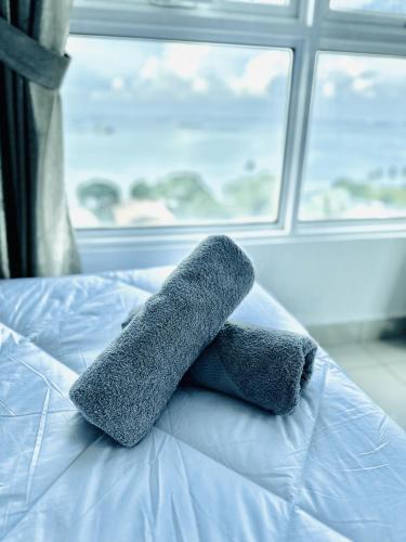 two towels on a bed in front of a window at 10pax 3-Bedroom l Seaview l Georgetown l Gleneagles l Mansion One in George Town