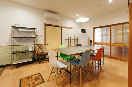 a kitchen with a table and chairs and a refrigerator at 海の陽 in Nonami