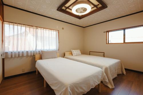 a bedroom with two beds and a window at 海の陽 in Nonami