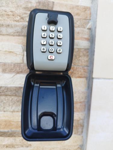 a cell phone hanging on a brick wall at chez jojo in Baie-Mahault